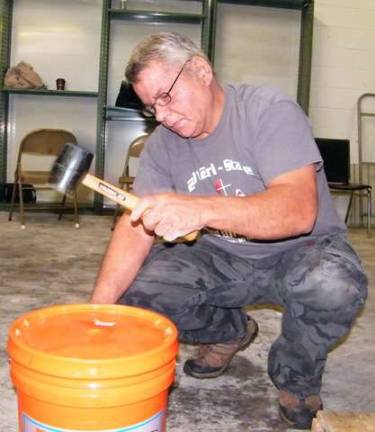 Volunteer Bob Terpenning seals the completed buckets, already double-checked for the correct amount of supplies just minutes prior