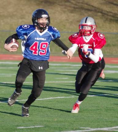 Blue All-Stars quarterback Alex Mastroianni is pursued by Red All-Stars defender Conor Milks in the Midgets game. Mastroianni plays for the Wallkill Valley Rangers. Milks plays for the High Point Hawks.