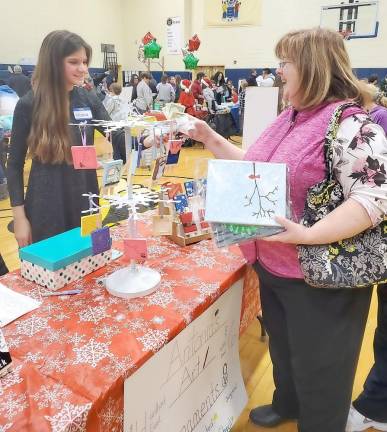 Antonia sells one of her hand-painted items to Terry Flynn.