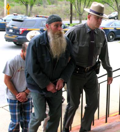 Peter M. Noger, 55, of Goshen, is escorted into Warwick Town Court on Thursday, April 28, where he was arraigned on a charge of second-degree conspiracy.