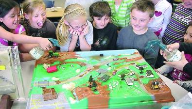 Children having fun with an Enviroscape (Photo provided)
