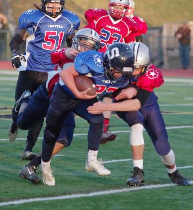 Red All-Stars defenders tackle Blue All-Stars ball carrier Sam Bushey in the Midget game. Bushey plays for the Sparta Spartans.