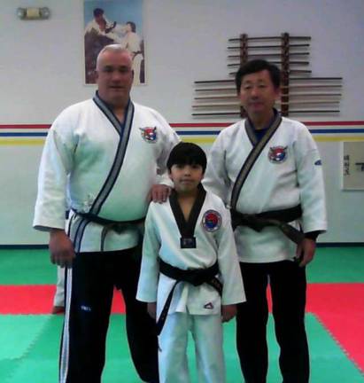 Master Instructor Phil Coleman, left, and Grand Master Kim are shown with student Daniel Phalon.