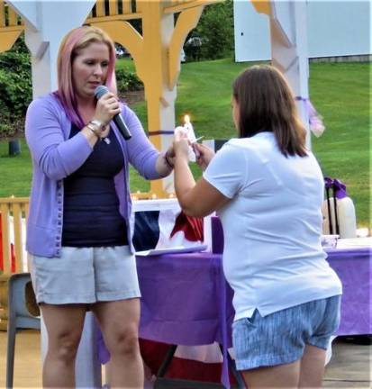 Vigil organizer Angela Lamendola helps begin the candle lighting at a vigil for Christine Solaro, 37, who was allegedly fatally shot by estranged husband Acting Newark Police Lt. John Formisano July 14.