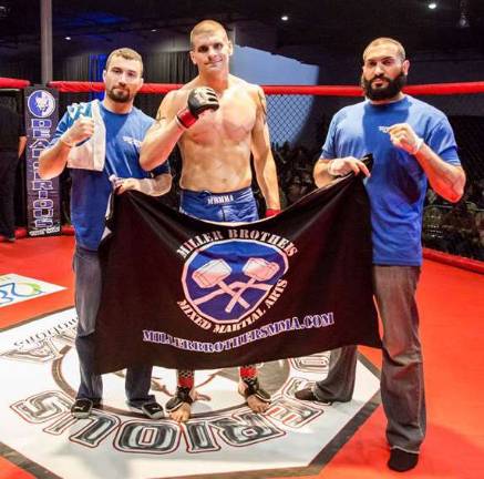 Sparta fighter wins MMA match in Freehold Tyler Bayer (center) celebrates his victory at Dead Serious MMA 25 with coaches Jim Fitzpatrick (left) and Amr Ibrahim (right)