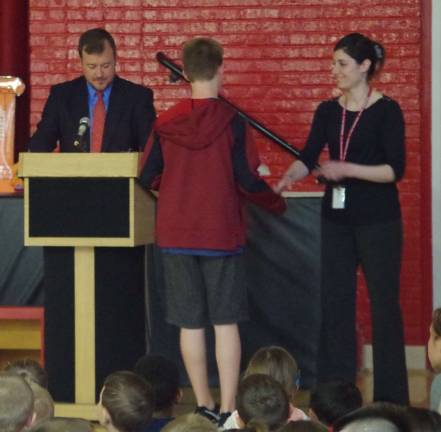 Standing behind the podium, Hamburg School&#xfe;&#xc4;&#xf4;s Chief School Administrator Roger Jinks, Jr. called students to the front of the room and recognized them for being named in their classes respective honor rolls.