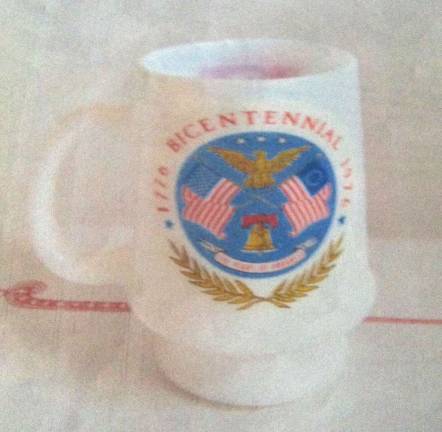 The Bicentennial logo designed by Ralph Marchese is shown on a mug.