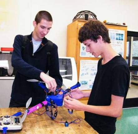 Students explore world of Maker Faire High Point High School seniors Corey Orlovsky, left, and Bob Burghart, right, are able to direct their quadcopter to fly anywhere in the world using a GPS attached to the machine.