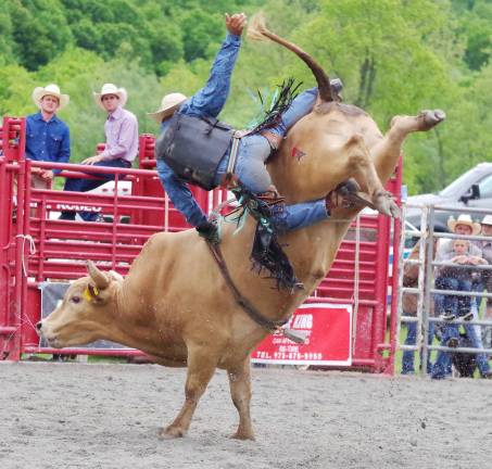 Cowboy Austin Beaty of Bedford, Virginia keeps his grip as he rides a big snotty bull in the bull riding event.