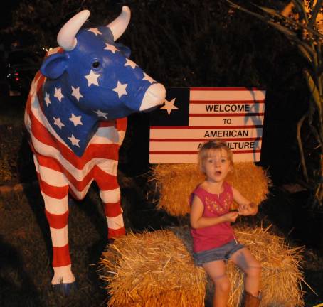 Summertime means County Fair Amelia Murphy, 4, from Wantage, rests on a hay bale at the agriculture exhibit. Photo by Nicholas Ortiz
