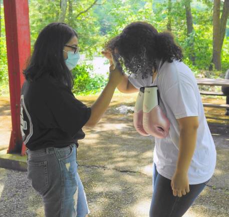 From left, assistant coach Gianna Alvarez takes Jadalin Gonzalez's temperature (Photo by Vera Olinski)