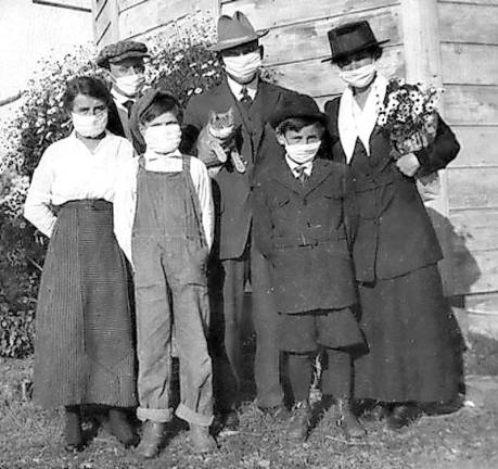 A masked family and their cat.