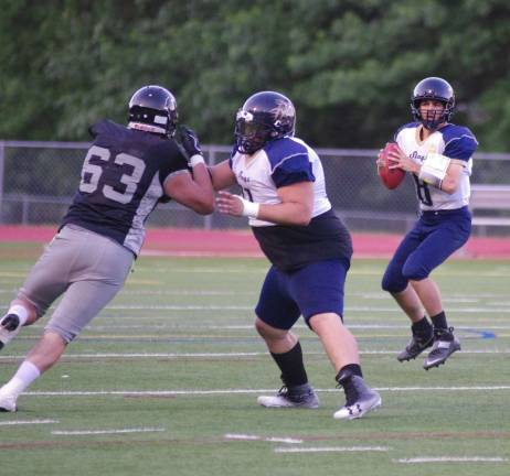 Sussex Stags quarterback Joseph Enslin holds the ball as his offensive line holds back the Central Pennsylvania Piranhas.