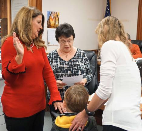 PHOTO BY VERA OLINSKI From left, Robin Hough is sworn in as Ogdensburg Clerk by Phyllis Drouin, while Hough's grandson and daughter hold the Bible.