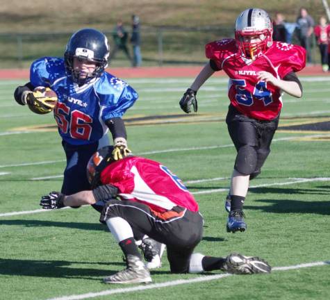 Blue All-Stars ball carrier Jack LaBanca stiff arms a Red All-Stars defender in the Super PeeWees game. LaBanca plays for the Sparta Spartans.