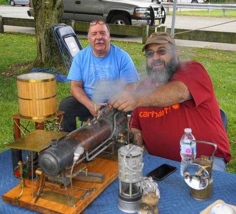 From left, Bill Kroth and Fred Lubbers demonstrate a steam engine and generator.