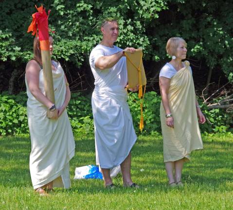 Wearing togas, Hamburg School history teacher Michael Blochinger starts the games with a proclamation. On the left is special education teacher Rachel Windish holding the Olympic torch and on the right is math teacher Marianne Allen.