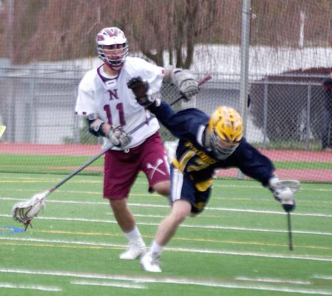 Far right Jefferson's Matt Bush stumbles after getting slashed with a stick. Bush scored three goals. Jefferson Township High School beat Newton High School in boys varsity lacrosse on Wednesday, April 22nd 2015. The final score was 10-1. The game was played at Newton High School in Newton, New Jersey.