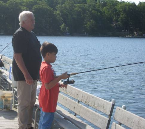 PHOTOS BY JANET REDYKE Eli and his grandpa fish off the dock at Highland Lakes&#x2019; Main lake. Eli later caught an extremely large fish.