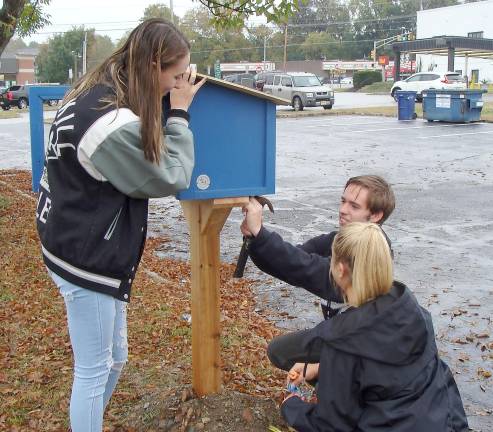 Riley Cunniffe, John Spadora and Danielle Fetzner assemble the Little Free Library.