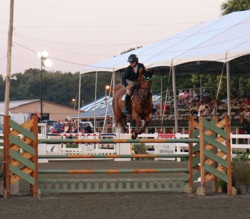 A rider and her horse make a jump.