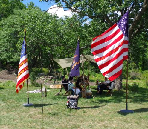 Members of the 27th Regiment of New Jersey, Company F relax in the shade behind the museum.