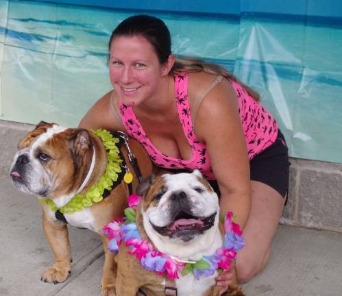 Posing in front of a tropical backdrop is Stockholm residents Kira Shellowsky and English Bulldogs Roxie and Leroy.