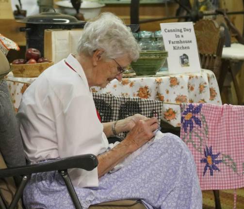 Nan Horsfield quietly stitches designs onto her handkerchief between presentations in the Snook Agricultural and Antique Pavillion at the 2019 NJ State Fair on Aug. 11, 2019.