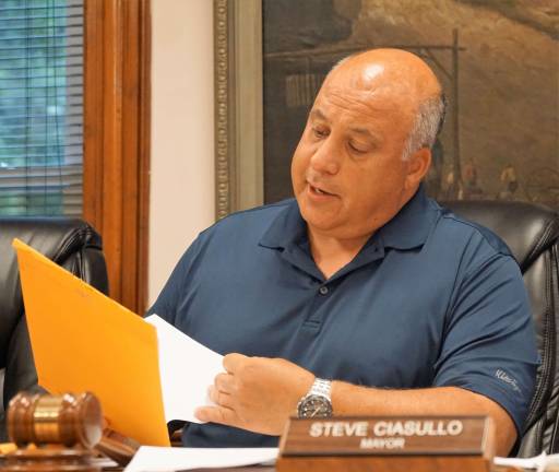 Mayor Steve Ciasullo reviews the permit paperwork to lower Heater's Pond Dam.