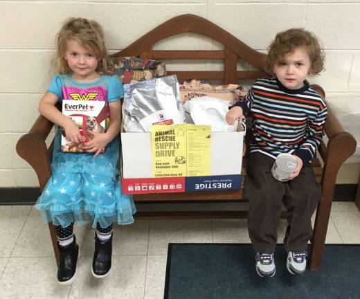 Pictured are Madaline Guddemi and Logan Paterson two Kindergarten students from Mrs. Roy's and Mrs. Maas' class at the Clifton E. Lawrence School doing their part in organizing the collected items.