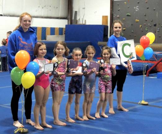 Coach Kelly Hurley and Gator team helpher Audey Biss, both of Sparta, present awards to their squad of Level 1 gymnasts.