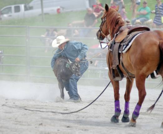 Rodeo competitor Robbie Erck of Fort Edward, New York handles a calf in the tie down roping event.