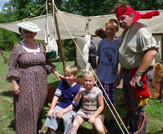 DAR member and Sparta resident Gail Shawger (left) poses with her Lederhaas family grandchildren Miles, 10, Macy, 8, Mason, 13, and &#xfe;&#xc4;&#xfa;Living History&#xfe;&#xc4;&#xf9; re-enactor Fred Schofer behind the Elias VanBunschooten Museum on Saturday.