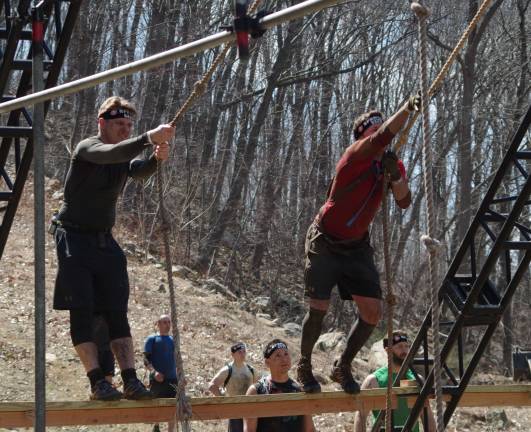 Mountain Creek hosts Spartan Race Participants swing over a water and mud-filled obstacle.