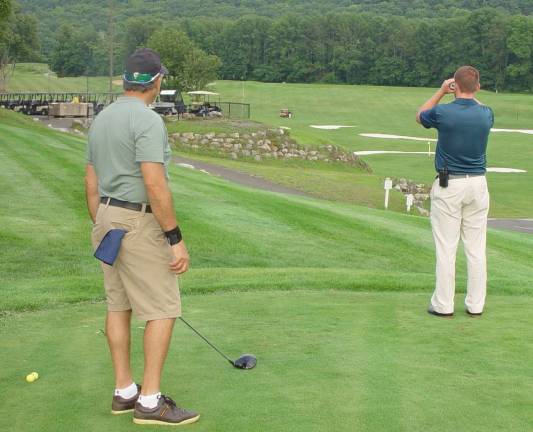 Black Bear Golf Club&#x2019;s GM and Event Coordinator Ryan Delaney uses a range finder to measure Joe Giammarino&#x2019;s shot.
