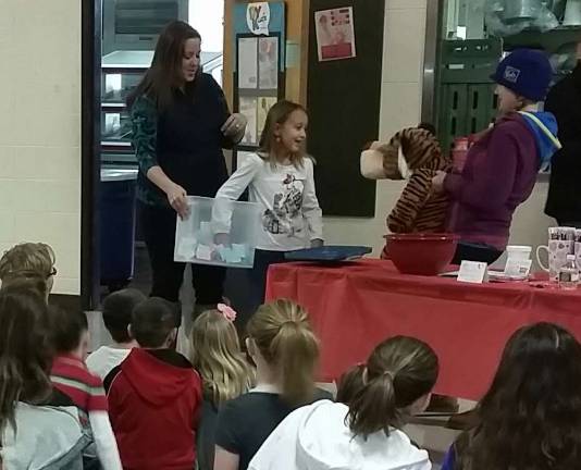 Lafayette PTO gives out muffins, donuts Christina Kinney and Megan Leto holding the raffle for the stuffed tiger, along with third-grade student Savannah Kinney picking the winning ticket