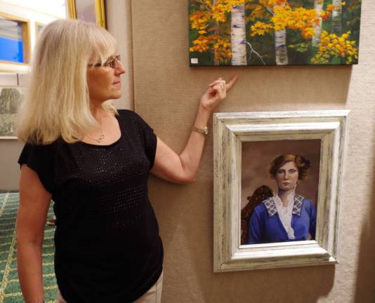 Artist Lois Semanek talks about one of her paintings shown at the Highland Lakes professional artist exhibit.