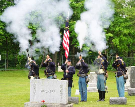 The Civil War Re-enactment Color Guard, 15th N.Y. Volunteer Cavalry, Co. L., gives Sergeant Francis M. Glynn a three gun salute.