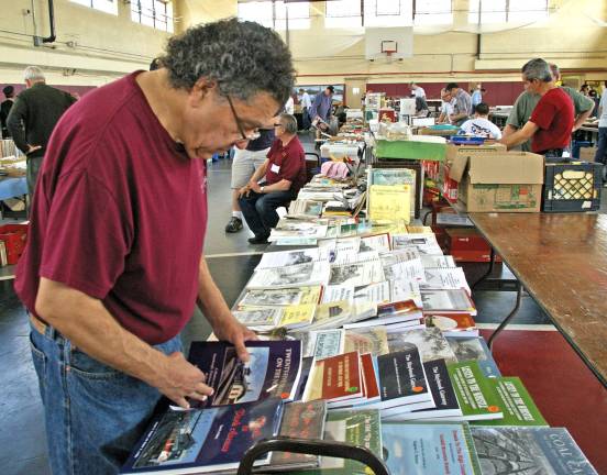 Club president John Bazelewich of Stockholm is tempted as he looks through railroad magazines for sale.