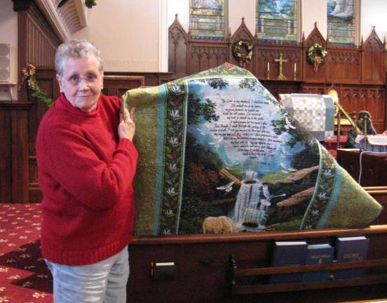 Winnie Jager displays the finished back of one of her quilts, which made her famous at the First Presbyterian quilt show (Photo by Ginny Privitar)