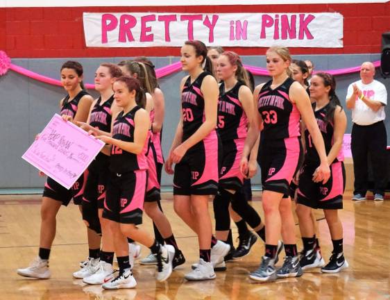 High Point basketball raises money for cancer survivors The High Point Girls' Varsity team carries a Pretty in Pink check to be presented.