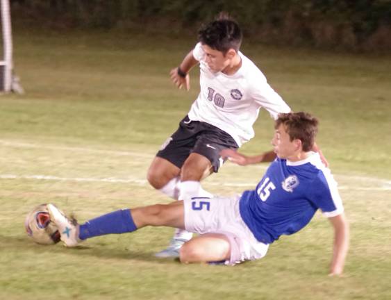 Kittatinny's Nile Mattar slides and kicks the ball away from Wallkill Valley's Carlos Mansilla in the first period.