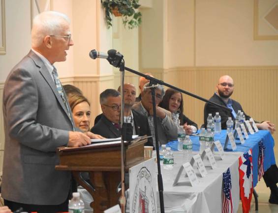 On left, Moderator John F. Kibildis says each Congressional candidate has position papers available.