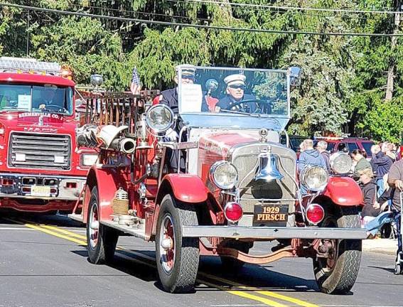 An antique firetruck is driven in the parade.