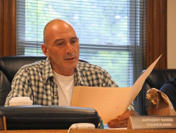 Councilman Anthony Nasisi reads bids for the historical building's new gas steam boiler.