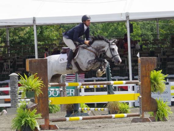 An equestrian competes through a series of jumps.
