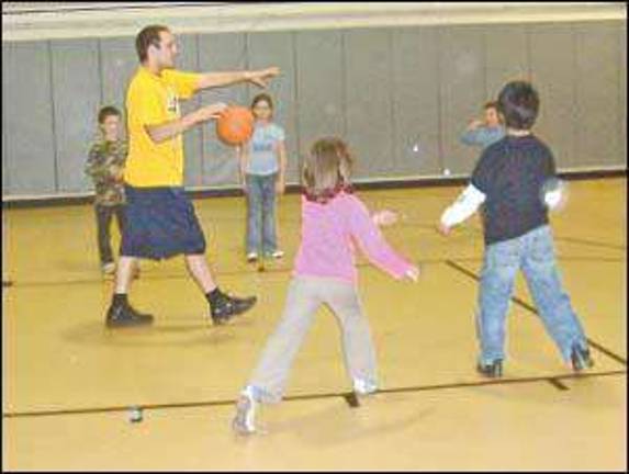 Student volunteer teaches basketball Student volunteer teaches basketball