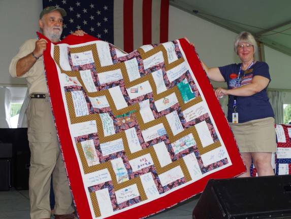Stanhope veteran Frank Arminio helps display a Quilt of Valor from presenter Barbara Thomas of Wantage.
