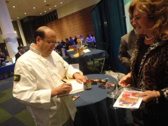 Celebrity chef Sal Scognamillo of the renowned Patsy's Italian Restaurant in Manhattan signs a copy of his cookbook for Penny Hollenstein, of Fredon.