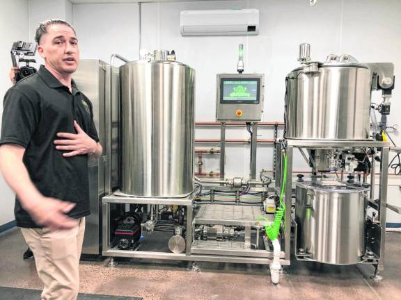 Seth Brown, director of manufacturing, gives a tour of the processing machines after the grand opening Thursday, March 14.